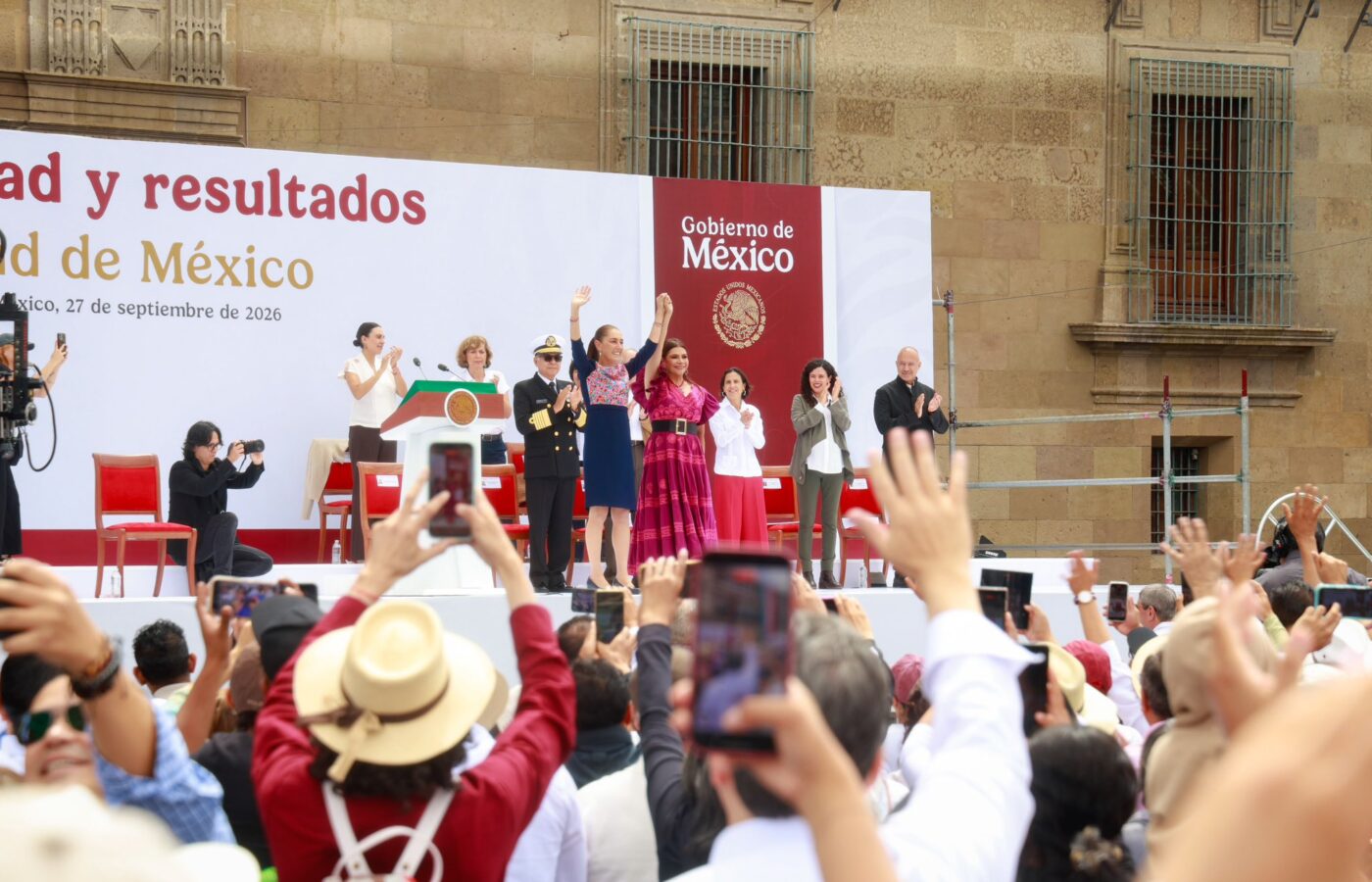 Claudia Sheinbaum saluda desde el templete, acompañada de autoridades, ante asistentes al Zócalo.