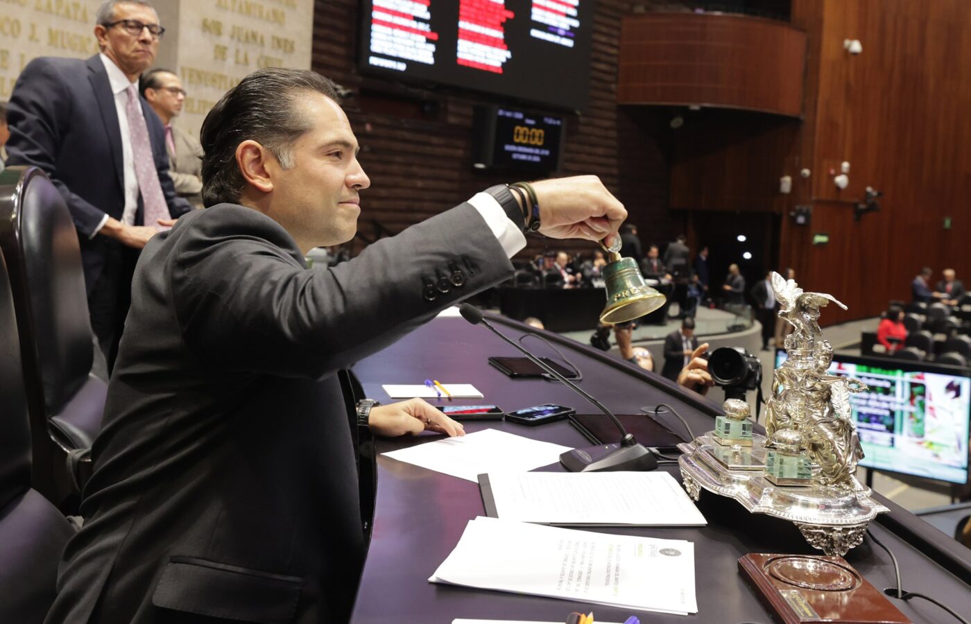 Legislador de la Cámara de Diputados toca la campana en la mesa de la Presidencia